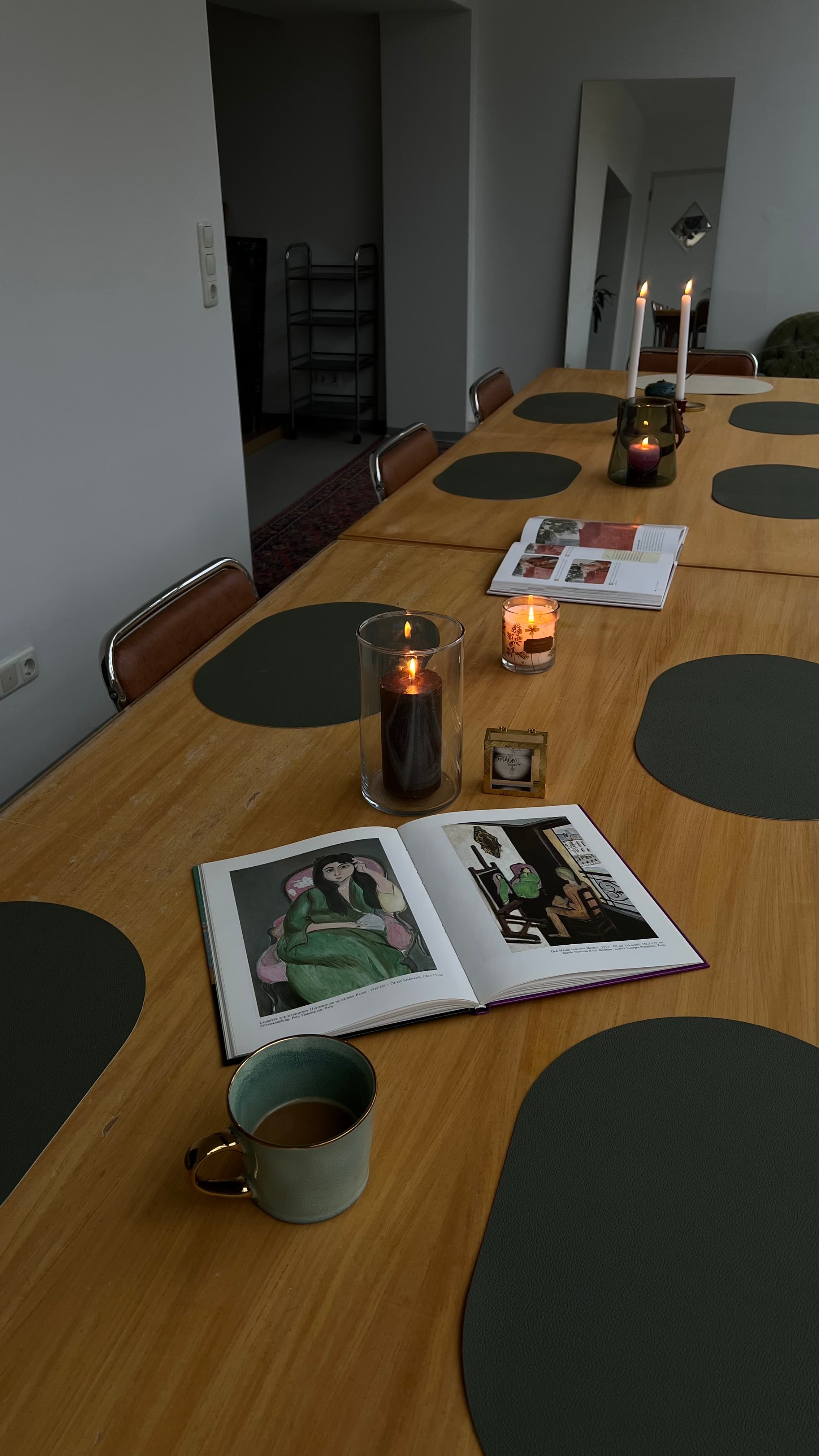Gedeckter langer Tisch im Wintergarten des HeimART Studios — Platzdeckchen, Kerzen, warmes Morgenlicht. Dein Platz ist schon vorbereitet.