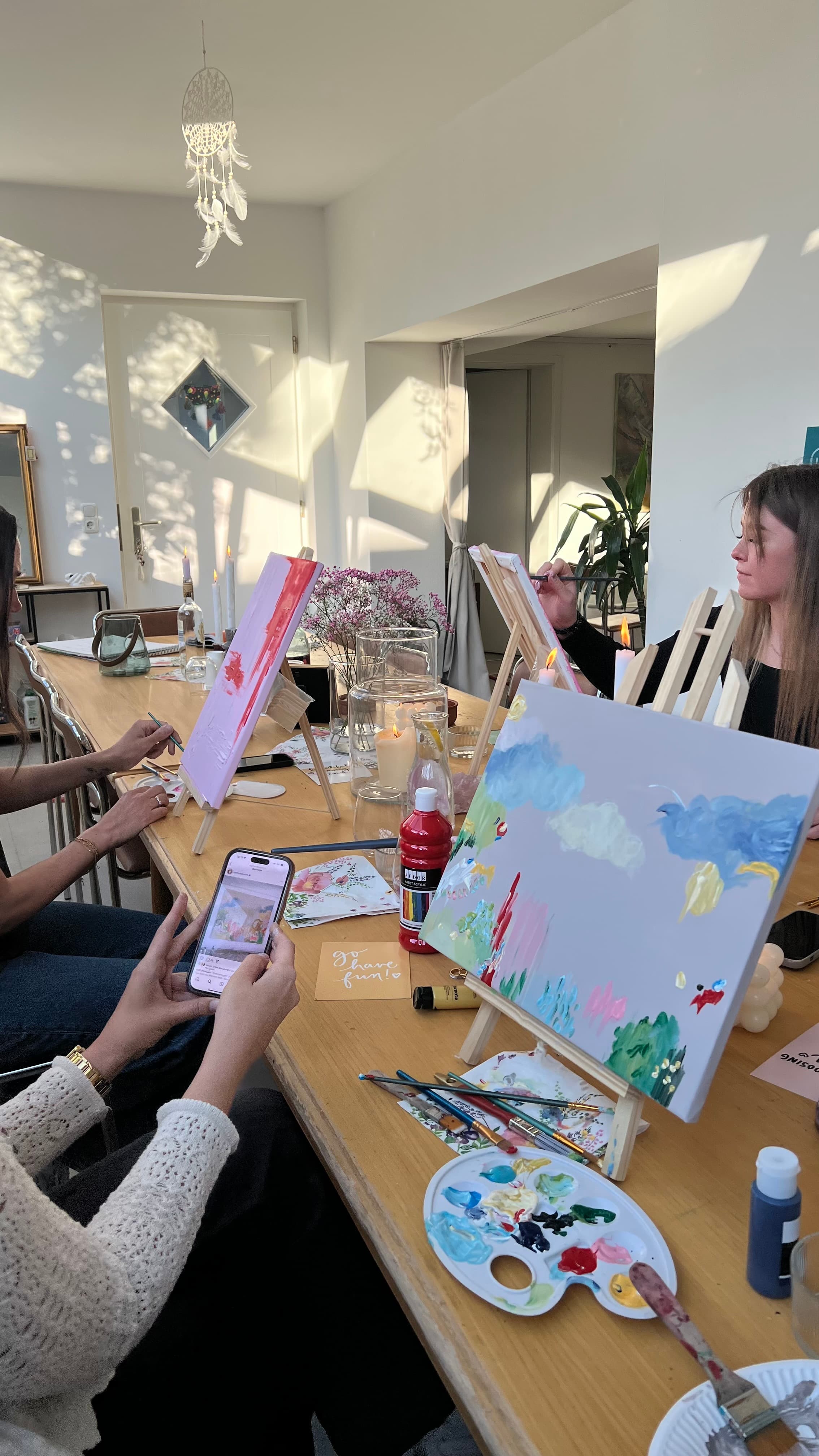 Hände beim Malen einer Leinwand mit Wolken-Motiv im Atelier — Pinsel und Palette in Reichweite